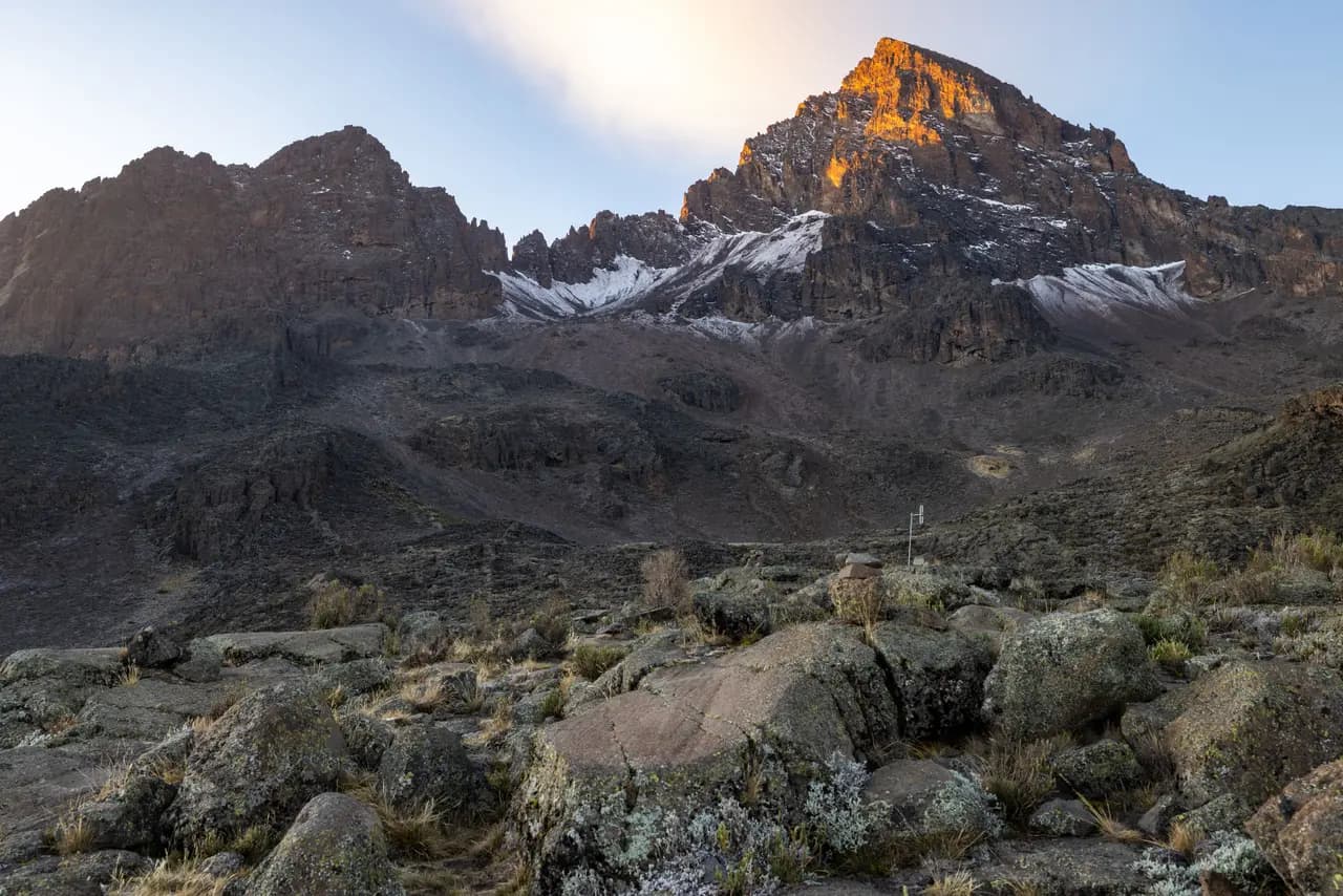Scenic view of mount kenya peaks at sunrise with rocky terrain and snow in the morning light