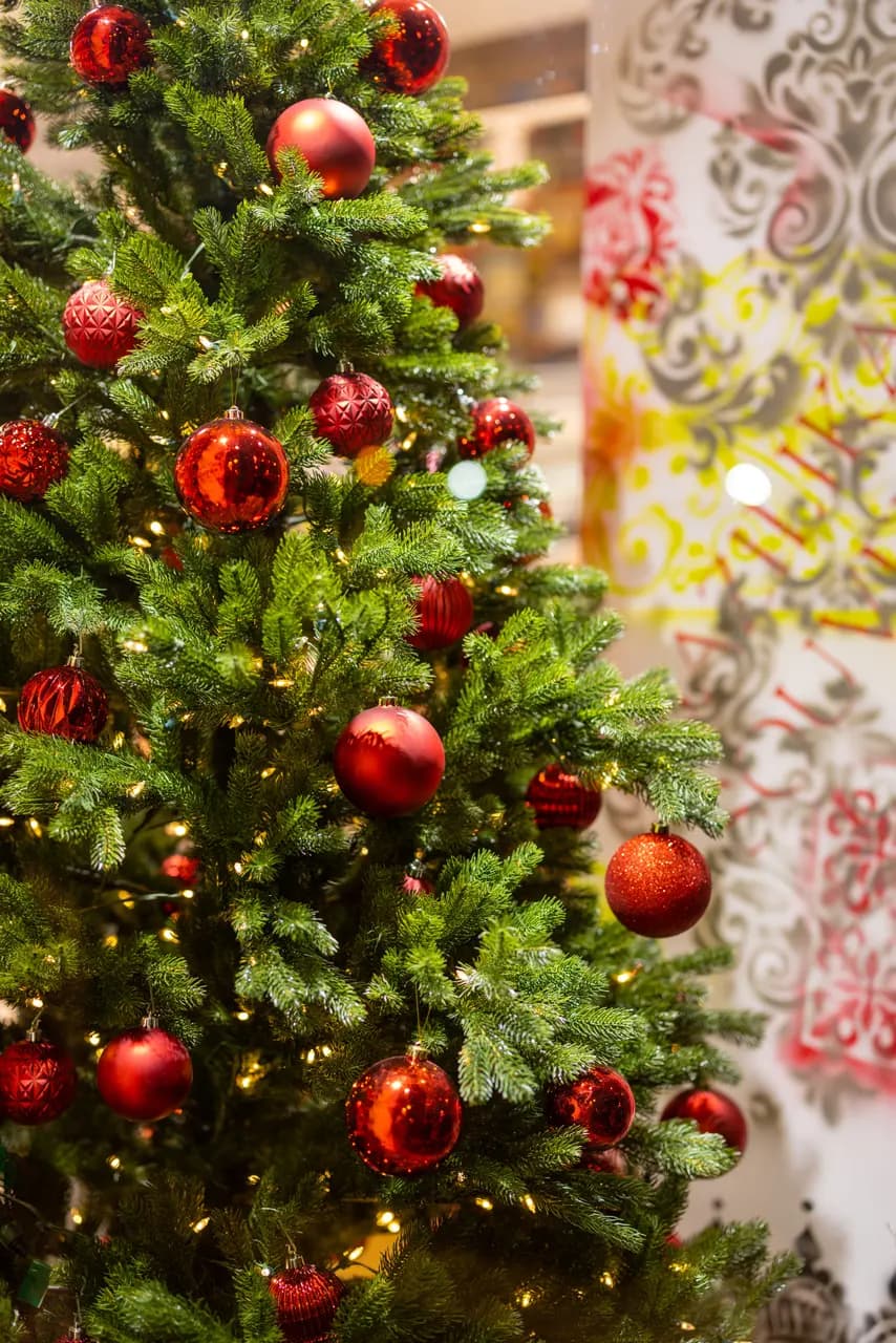 Decorated christmas tree with red ornaments and glowing fairy lights for holiday season celebration